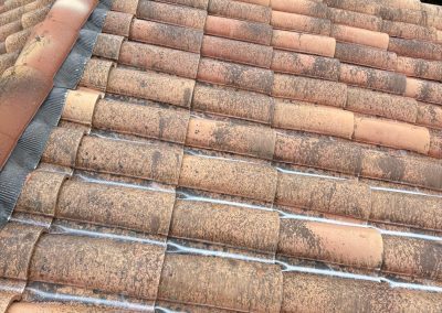 Application d'un traitement anti-mousse et fongicide professionnel sur une toiture en tuiles romanes autour de Besançon.