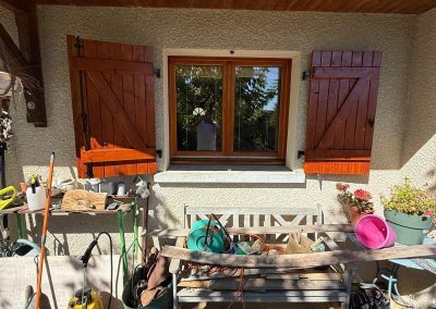 Entretien et rénovation esthétique de volets battants en bois sur une façade extérieure à Thise.